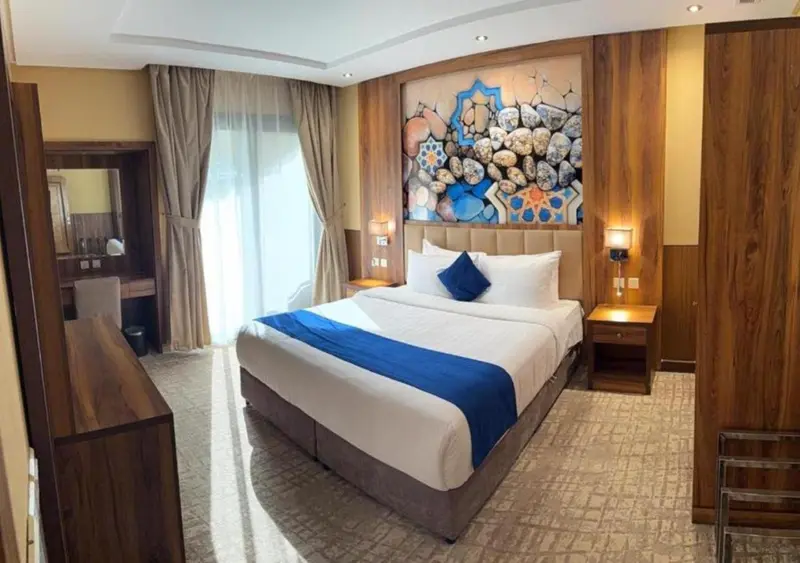 Chambre d'hôtel avec un grand lit et un décor mural.