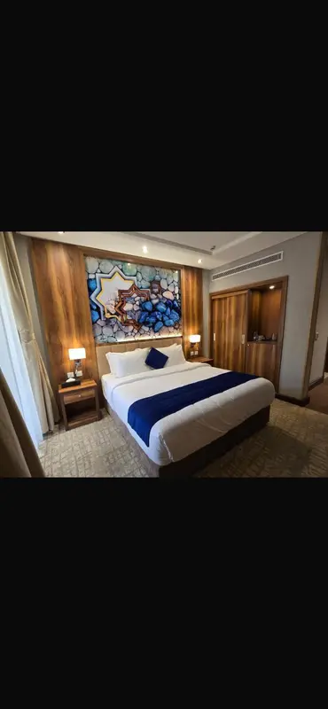 Une chambre d'hôtel moderne avec un grand lit et une décoration murale colorée.