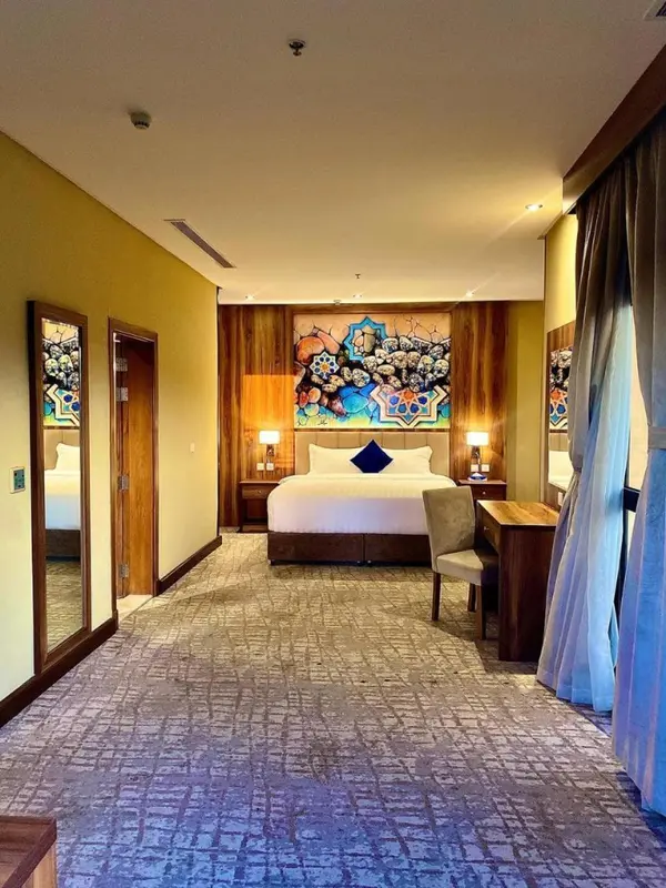 Une chambre d'hôtel lumineuse avec un grand lit et un bureau.