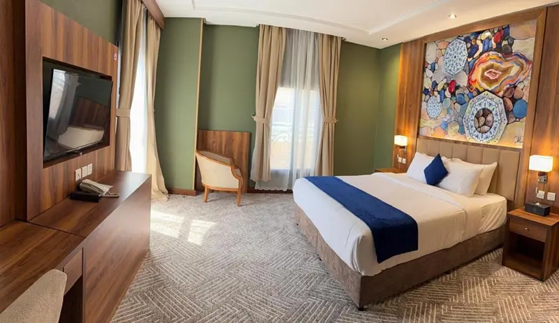 Chambre d'hôtel lumineuse avec un grand lit et un coin salon.
