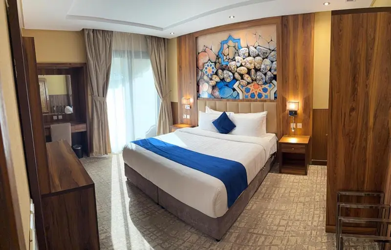 Une chambre d'hotel avec un grand lit et un décor mural.