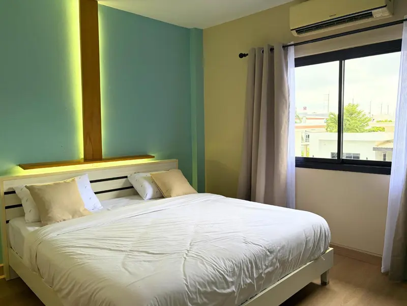 Une chambre lumineuse avec un lit double et une fenêtre.