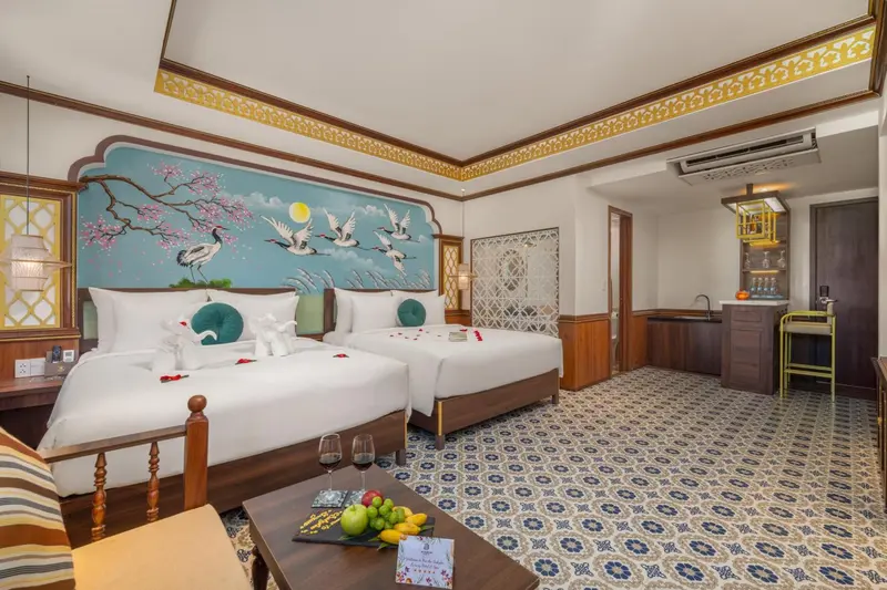 Chambre avec deux lits simples et une décoration murale florale.