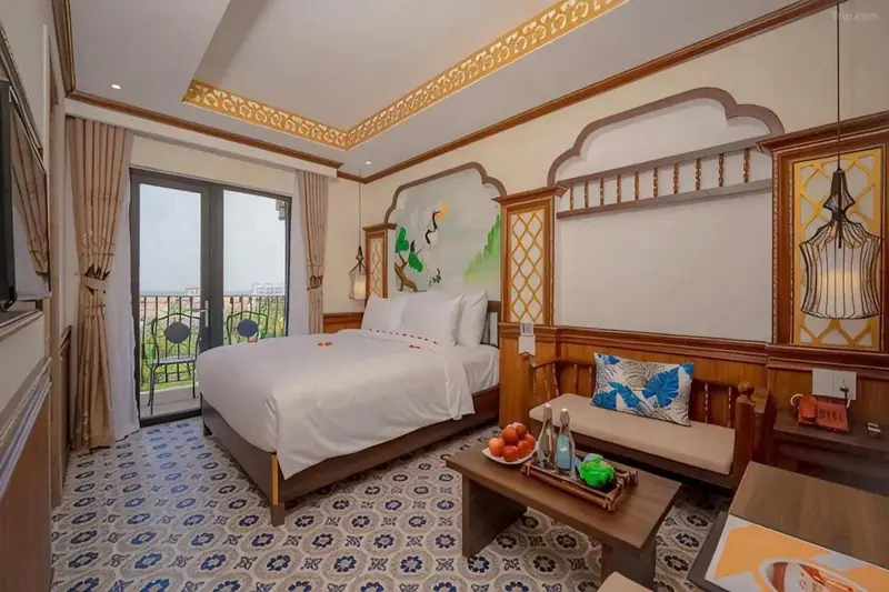 Chambre lumineuse avec un grand lit et un décor floral.