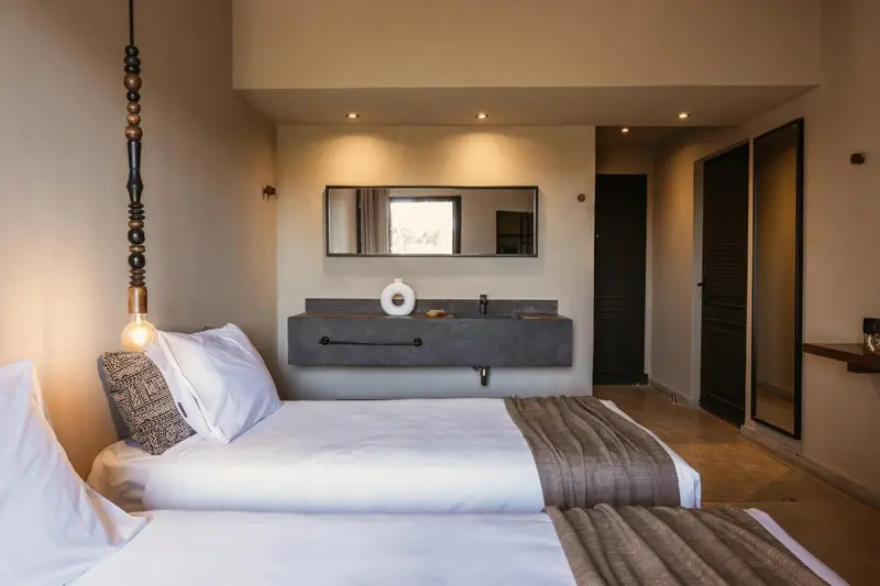 Une chambre lumineuse avec un lit double et un lavabo moderne.