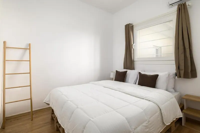 Une chambre lumineuse avec un lit double et une décoration sobre.