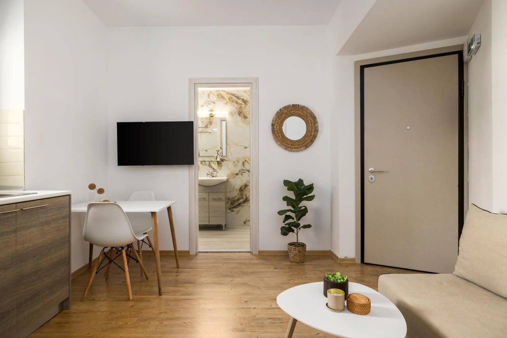 Une pièce lumineuse avec un canapé, une table et un téléviseur.