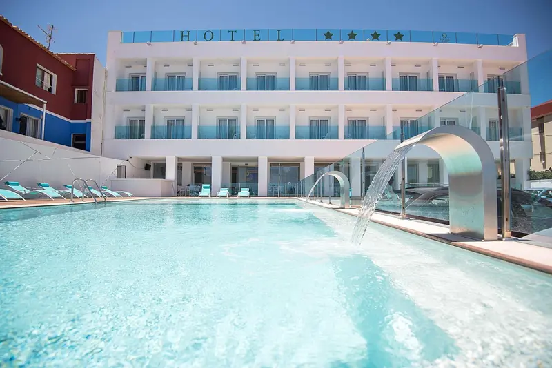 Vue d'un hôtel avec piscine et cascade d'eau.