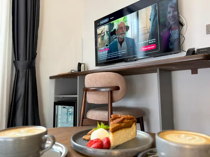 Une table basse présente une part de gâteau aux fruits frais et deux tasses de café.