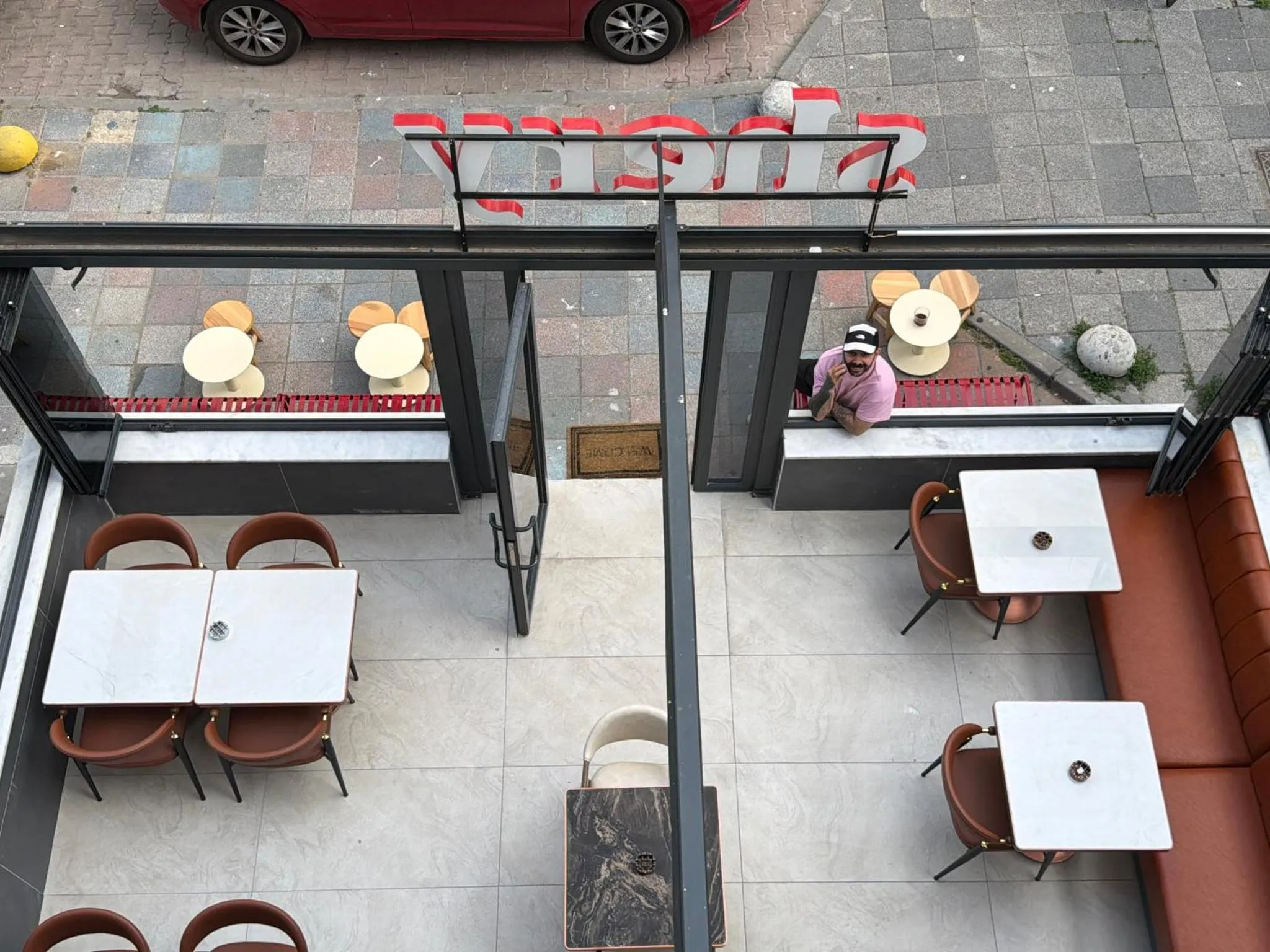 Tables et chaises dans un espace intérieur lumineux avec une vue sur une terrasse.