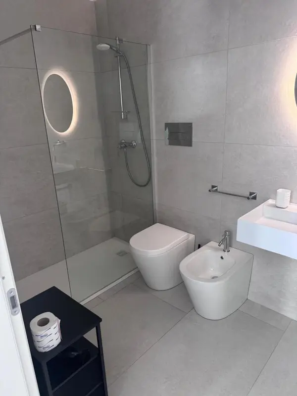 Une salle de bain moderne avec douche à l'italienne et sanitaires.