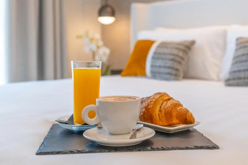 Un petit-déjeuner est servi sur un lit dans une chambre d'hôtel.