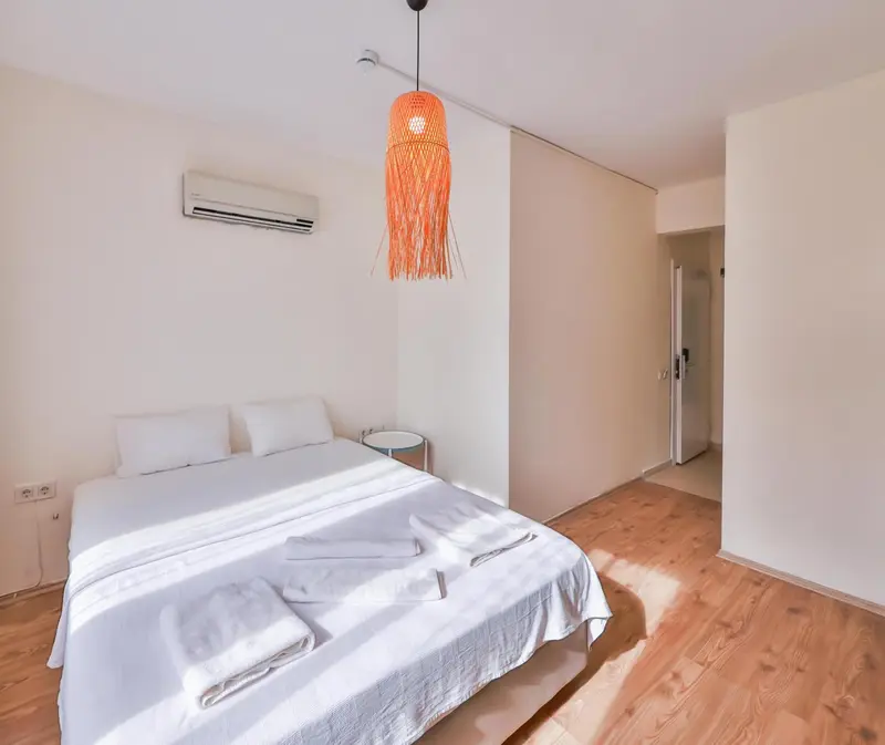 Une chambre lumineuse avec un lit double et une décoration minimaliste.