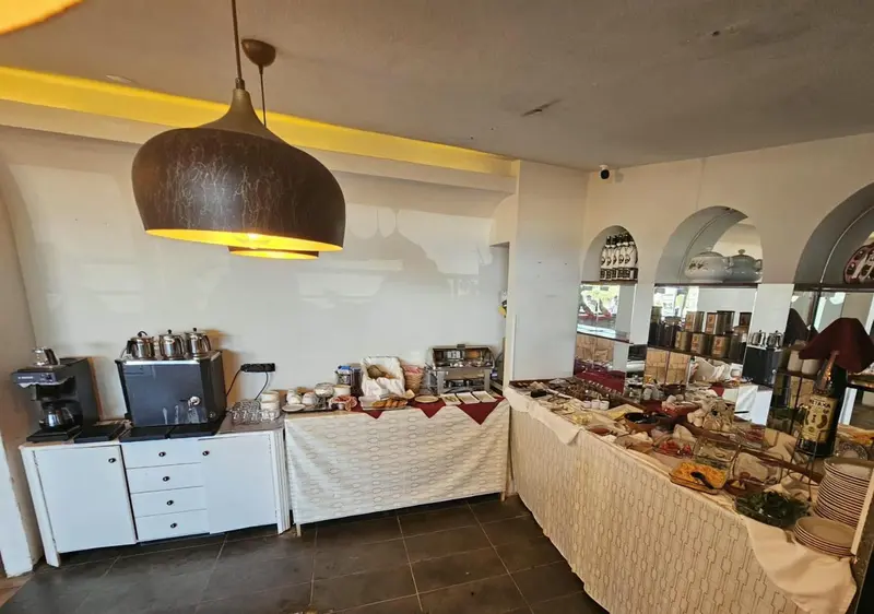 Un buffet propose une variété de plats et de boissons dans une salle lumineuse.