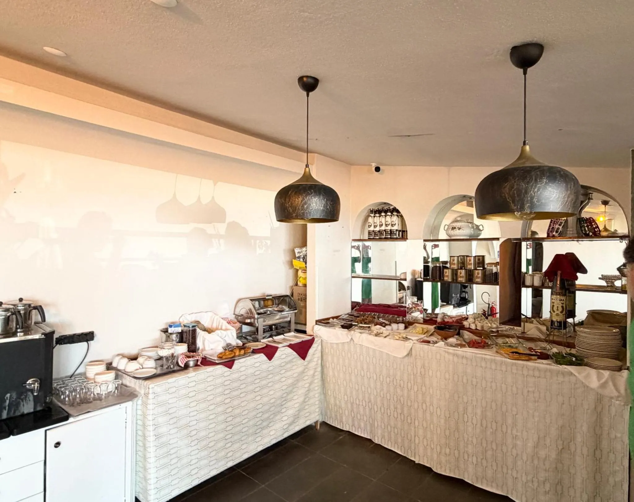 Un buffet propose une variété de plats et de boissons dans une salle lumineuse.