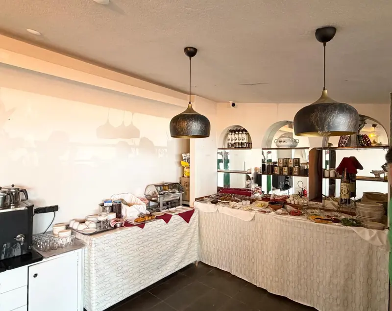 Un buffet propose une variété de plats et de boissons dans une salle lumineuse.