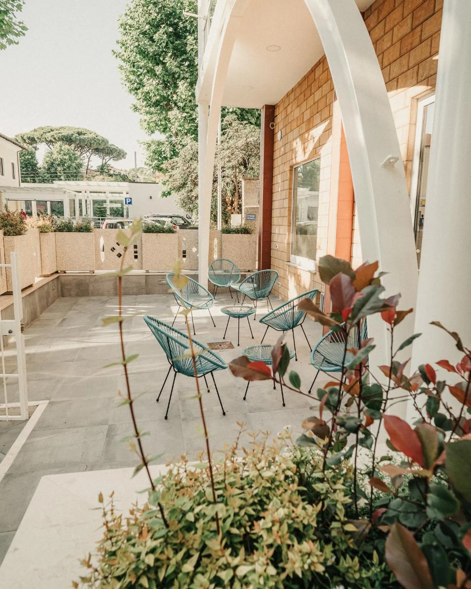 Terrasse ombragée avec mobilier en métal et plantes en pot.