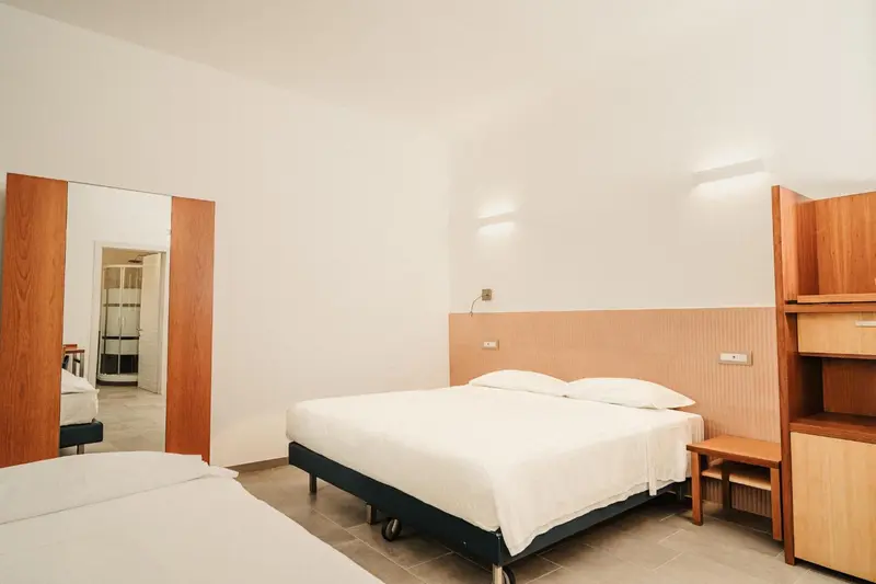 Une chambre lumineuse avec un lit double et un lit simple.