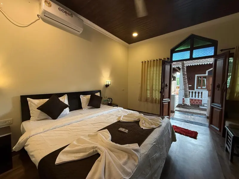 Une chambre lumineuse avec un grand lit et un accès à une terrasse.