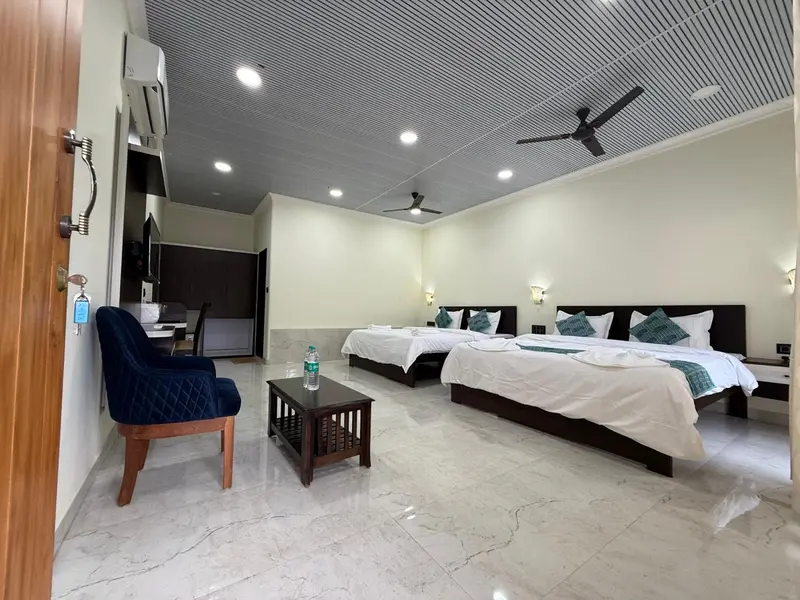 Une chambre lumineuse avec deux lits simples et un coin salon.