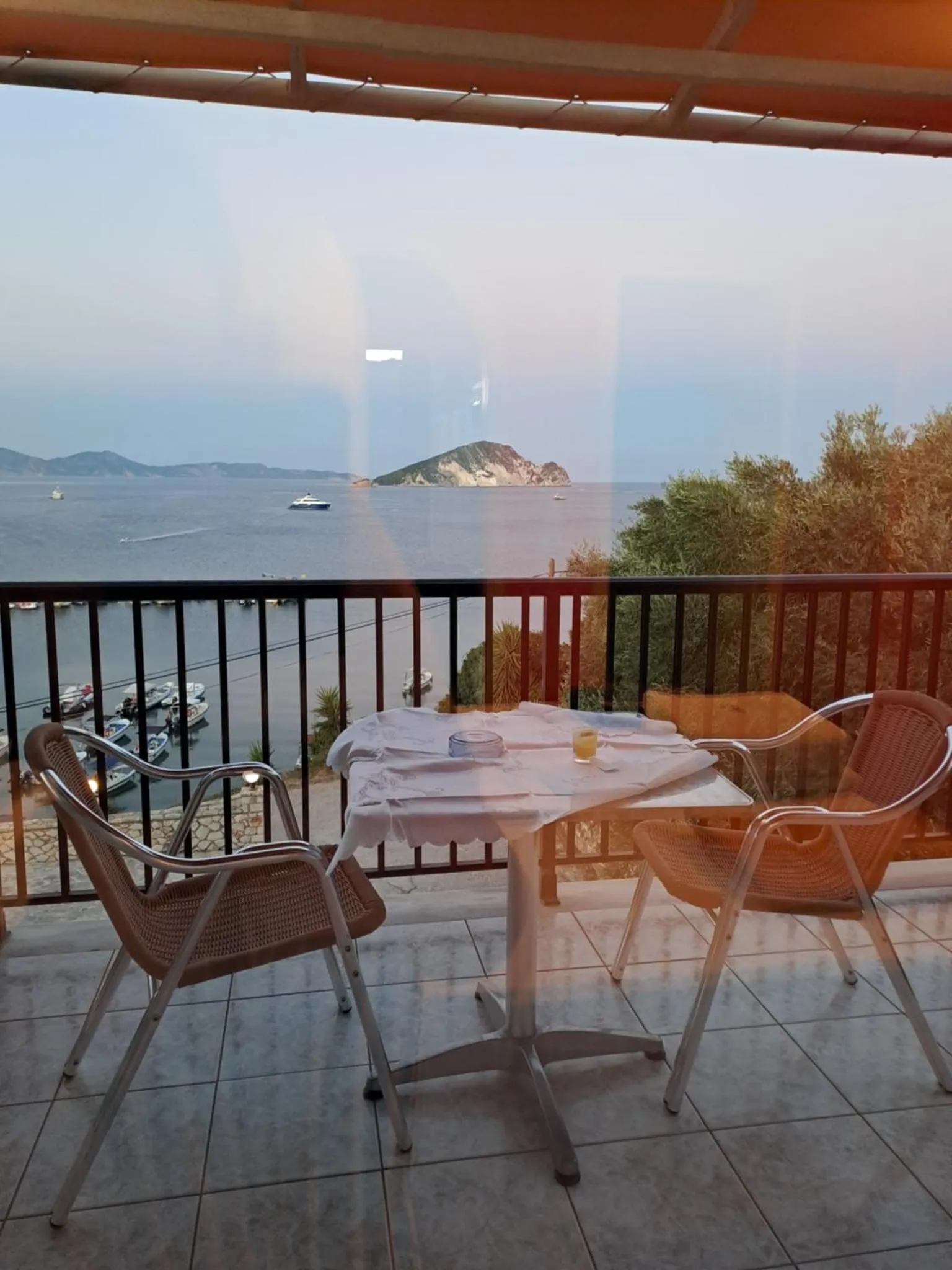 Terrasse avec table et chaises donnant sur la mer.