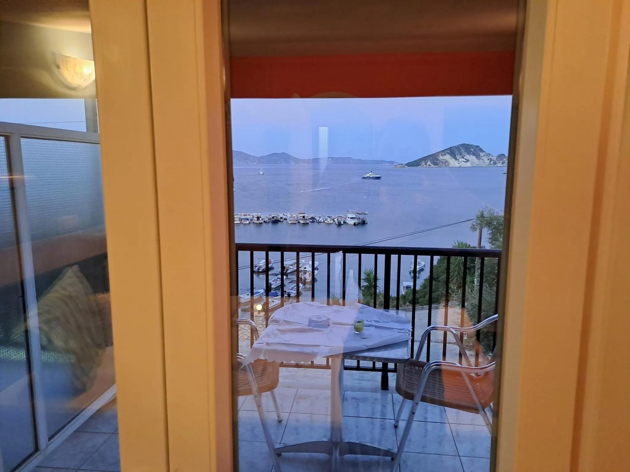 Terrasse avec table et chaises donnant sur la mer.
