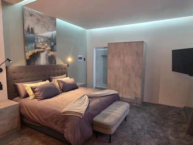 Une chambre moderne avec un grand lit et un tableau décoratif.