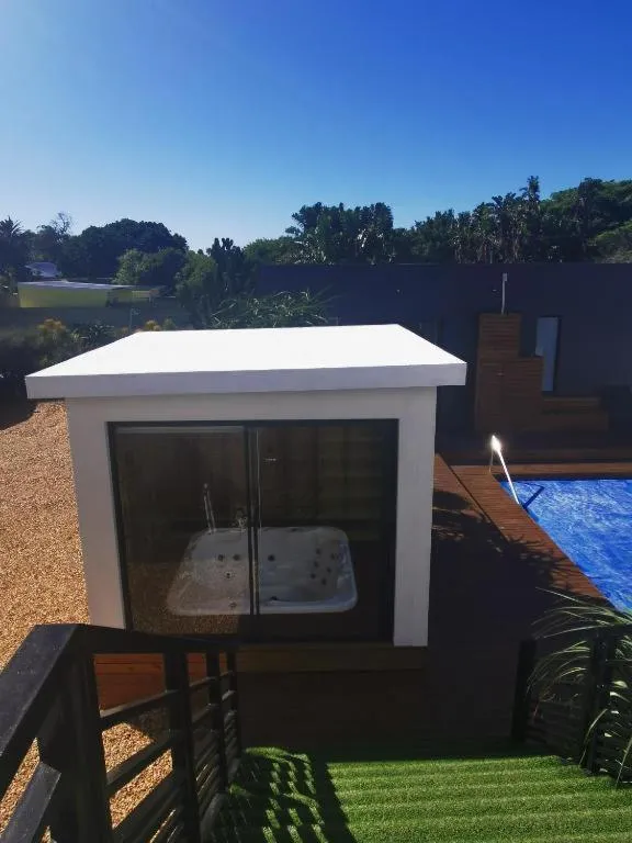 Un jacuzzi extérieur blanc est installé sur une terrasse en bois.