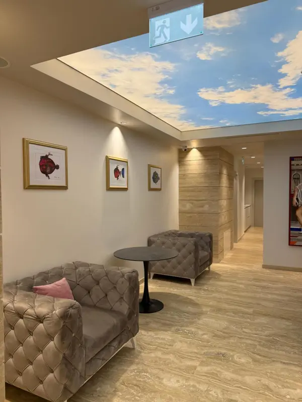 Un couloir d'hôtel avec des fauteuils et des tableaux décoratifs.