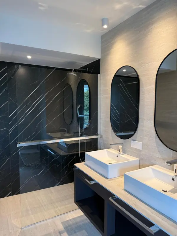 Une salle de bain moderne avec deux vasques et une douche à l'italienne.