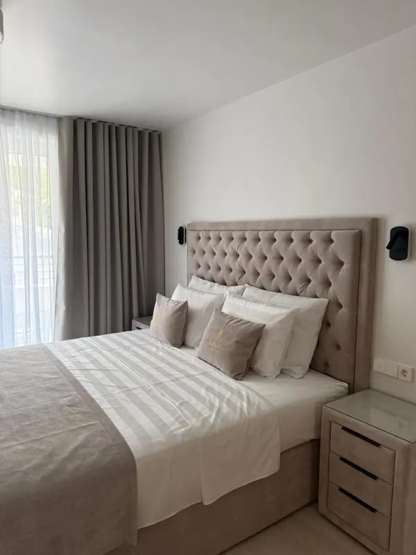 Une chambre avec un grand lit recouvert d'une couette et de plusieurs oreillers.