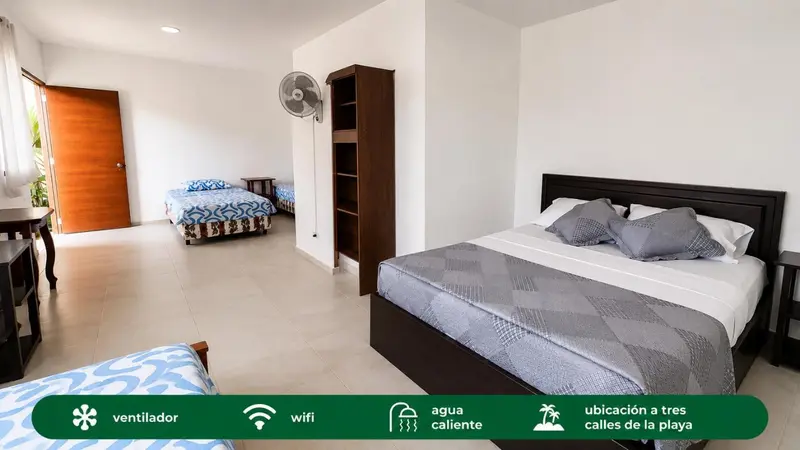 Une chambre lumineuse avec deux lits doubles et un ventilateur.