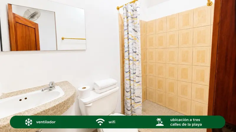 Une salle de bain claire avec douche et lavabo.