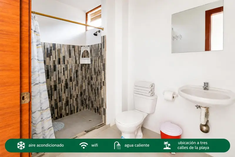 Une salle de bain claire avec douche à l'italienne et lavabo.