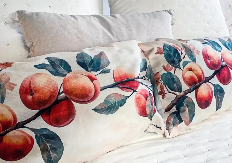 Coussins décoratifs à motifs floraux reposant sur un lit blanc.