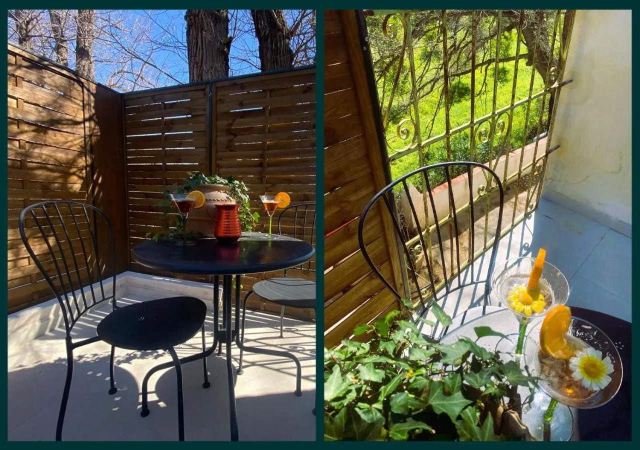 Une table ronde avec des boissons colorées sur une terrasse en bois.