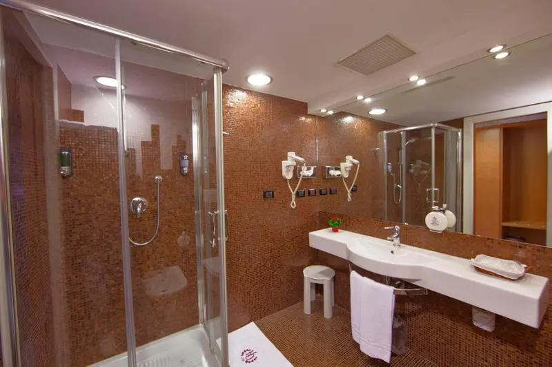 Une salle de bain moderne avec douche à l'italienne et vasque blanche.