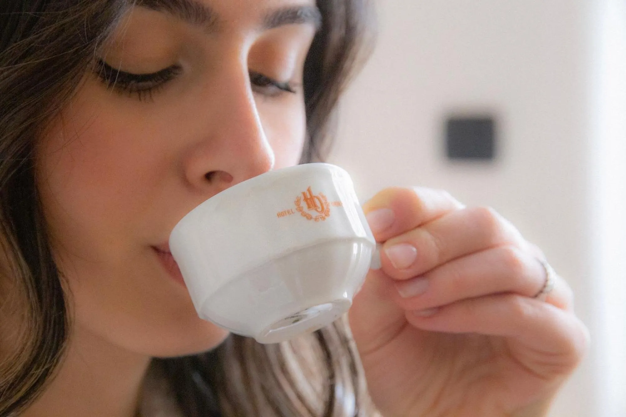 Une femme boit une tasse de café.