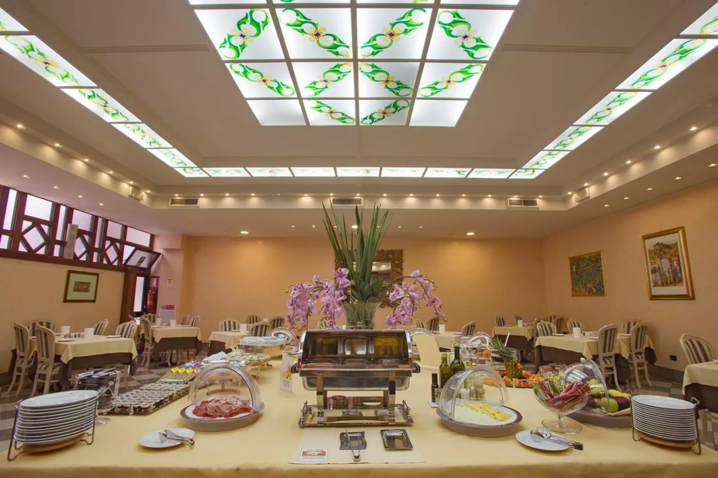 Une salle lumineuse avec des tables dressées pour un buffet.