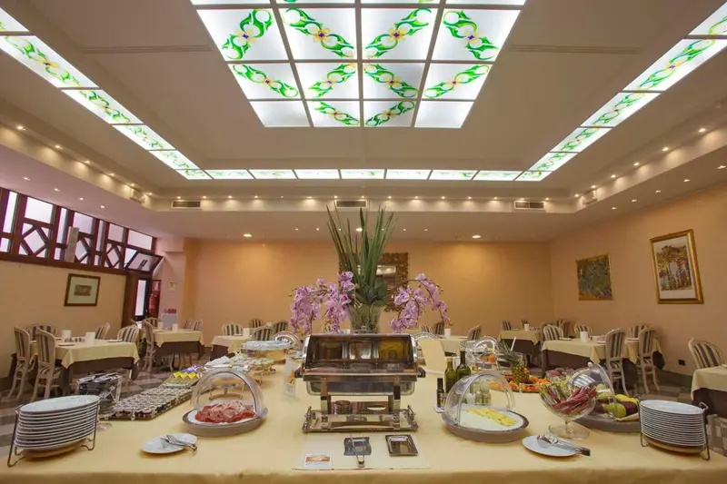 Une salle lumineuse avec des tables dressées pour un buffet.