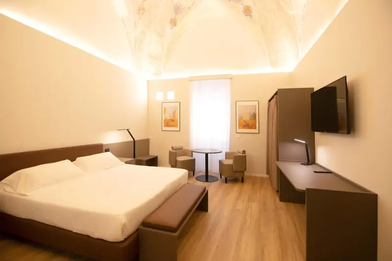 Une chambre lumineuse avec un grand lit et un coin salon.
