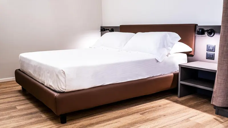 Une chambre avec un lit double et une table de chevet.