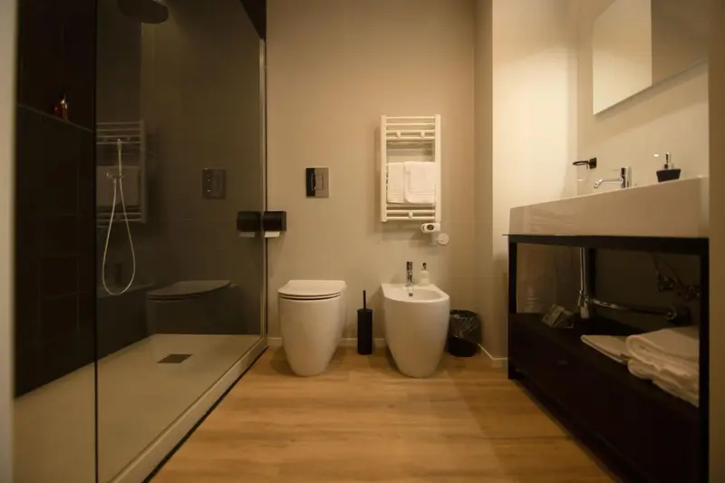 Une salle de bain moderne avec douche à l'italienne, toilettes et bidet.