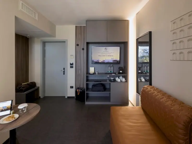 Une chambre moderne avec un canapé, une table basse et un téléviseur mural.