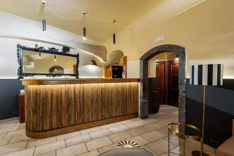 Un comptoir d'accueil en bois clair dans un hall d'hôtel.