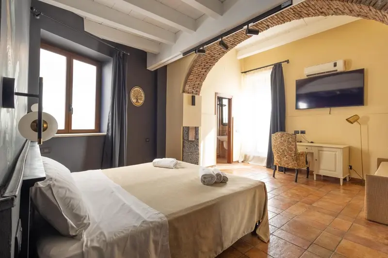 Une chambre lumineuse avec un grand lit et un bureau.