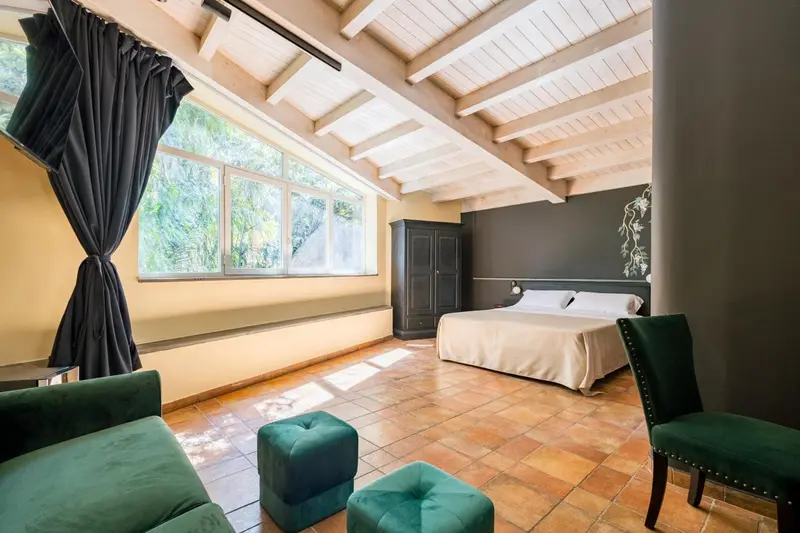Une chambre lumineuse avec deux lits simples et un coin salon.