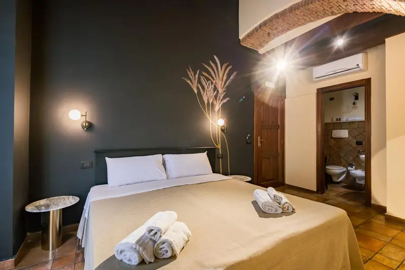 Une chambre à coucher lumineuse avec un grand lit et un accès à une salle de bain.