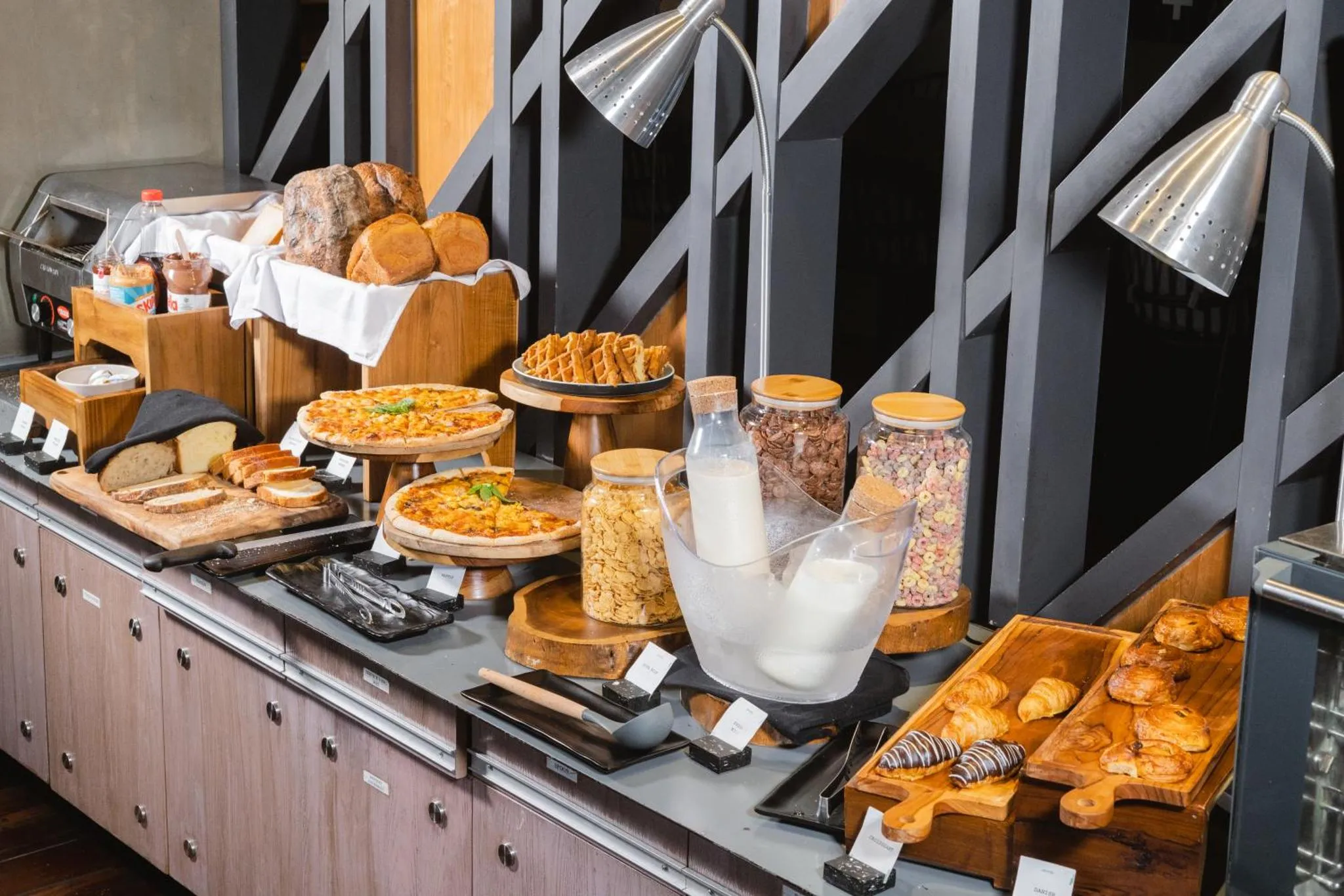 Un buffet propose une variété de pains, pâtisseries et céréales.