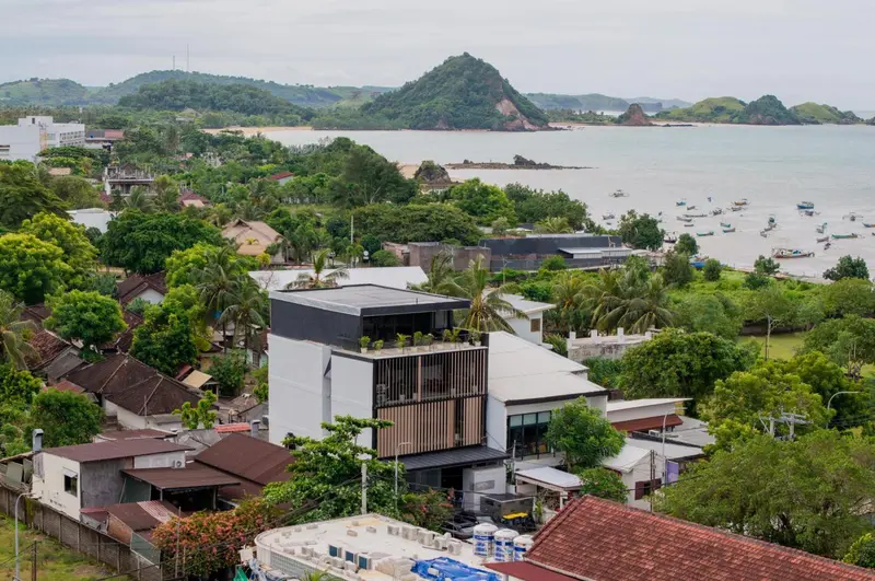 Vue aérienne d'une architecture moderne au milieu d'une végétation luxuriante et d'une côte.
